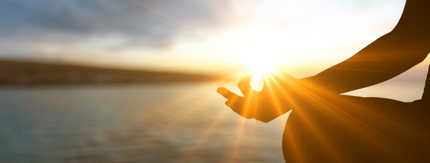 sun streaming through hand in meditation mudra