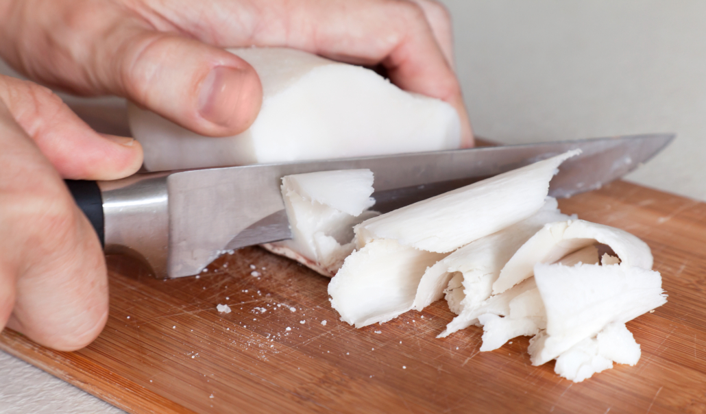 Salted white pork fat slicing on a cutting board