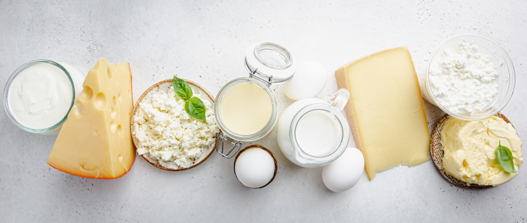 Fresh dairy products, milk, cottage cheese, eggs, yogurt, sour cream and butter on white background, top view