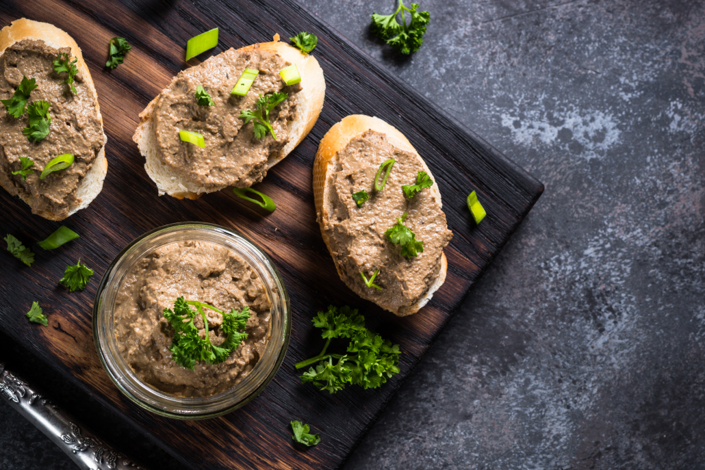 Pate from beef liver. Sandwiches with bread, pate and greens, dark stone table. Top view.