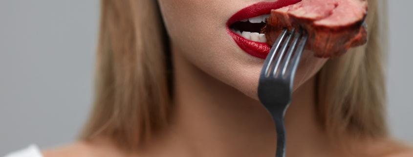 Woman Eating Food. Hungry Female With Beautiful Face, Red Lips Eats Delicious Juicy Grilled Meat. Healthy Girl's Mouth Biting Slice Of Tasty Beef Steak On Fork. Nutrition Concept. High Resolution