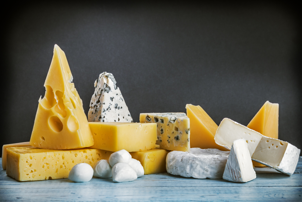 assorted cheeses, soft, hard, rennet and brine on a black background