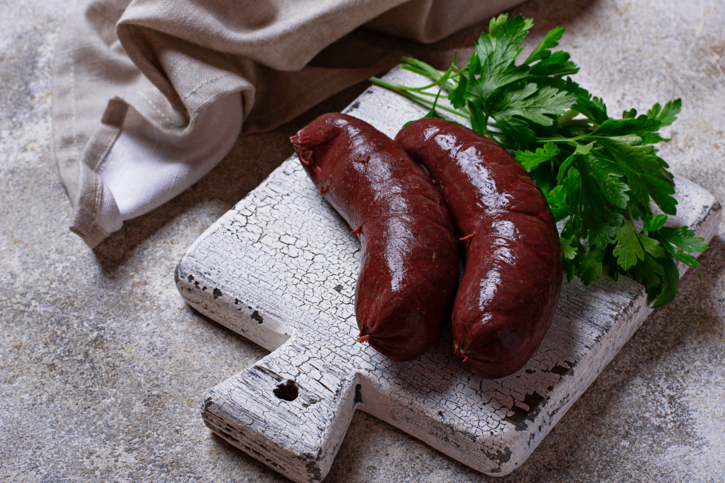 Homemade uncooked black pudding sausages on cutting board