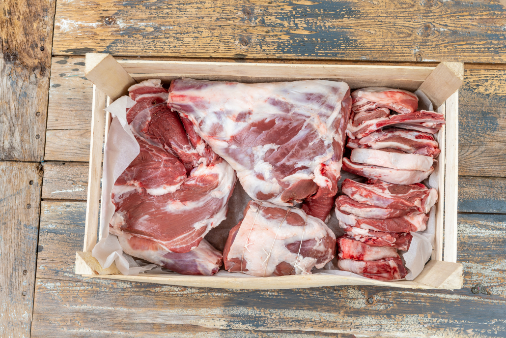 Fresh and raw sheep or lamb meat pieces for sale on wooden backgrounde