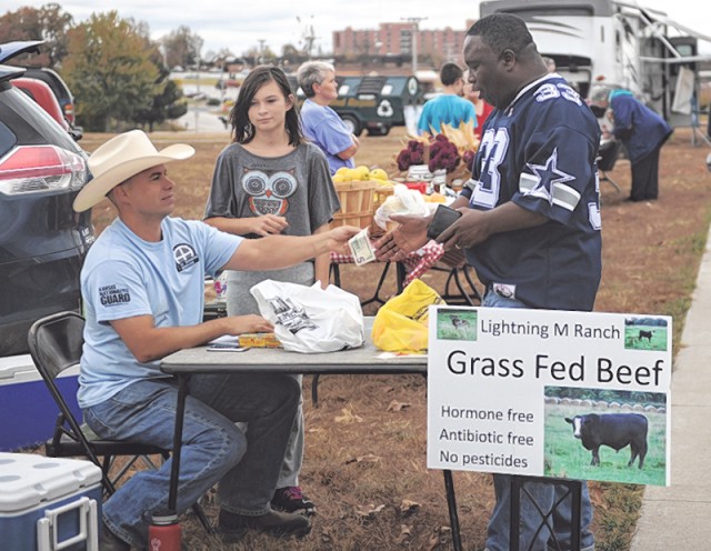 man buying meat from farmers market stand