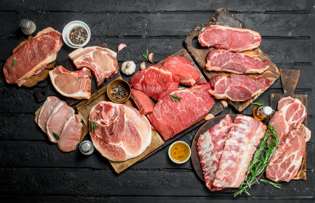 Raw meat. Different kinds of pork and beef meat. On a black rustic background.
