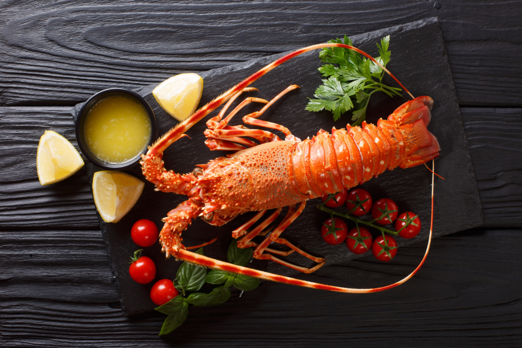 Expensive food: spiny boiled lobster with fresh tomato, lemon an