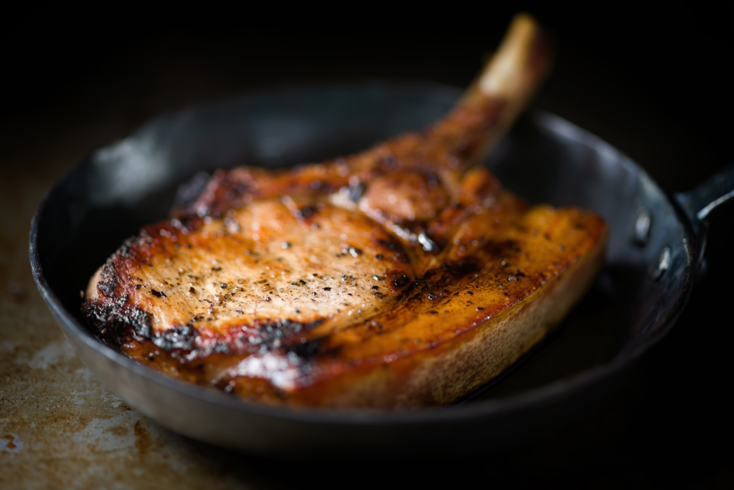 close up of huge rustic pan fried pork chop