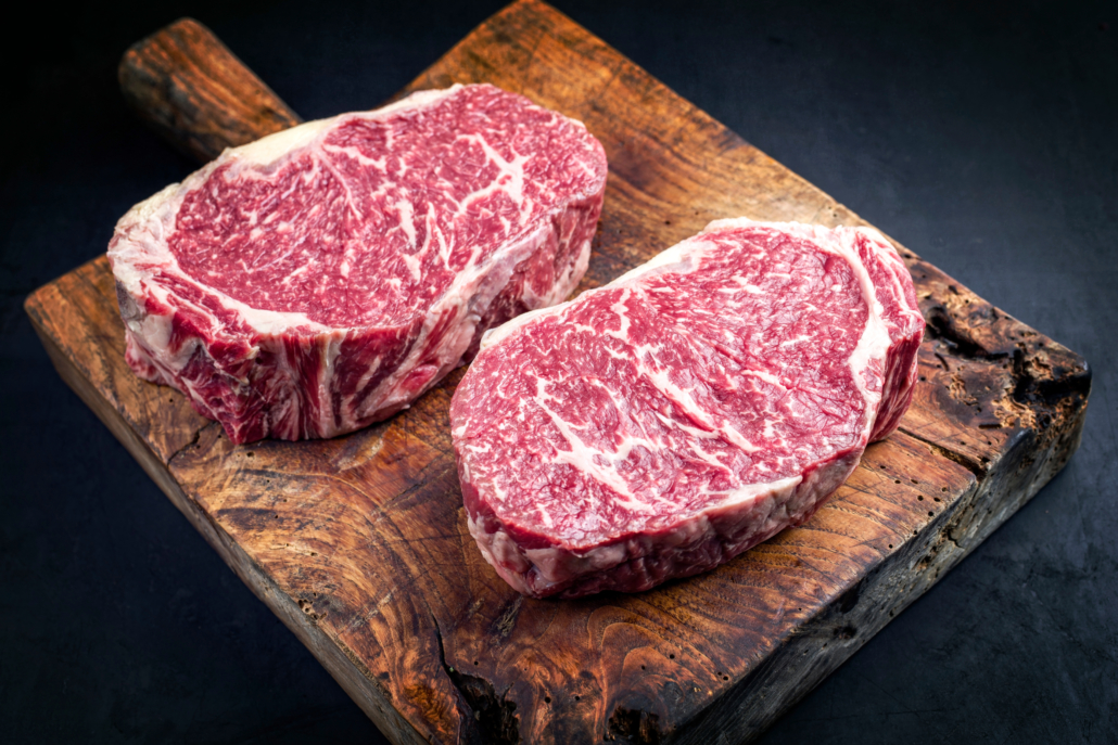 Raw dry aged wagyu entrecote beef steak roast as closeup on a rustic wooden cutting board