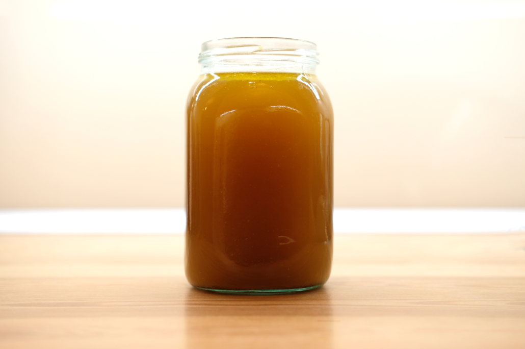 jar of beef bone broth on wooden kitchen toable top
