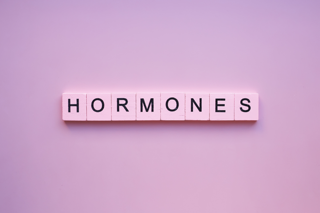 Hormones word wooden cubes on a pink background