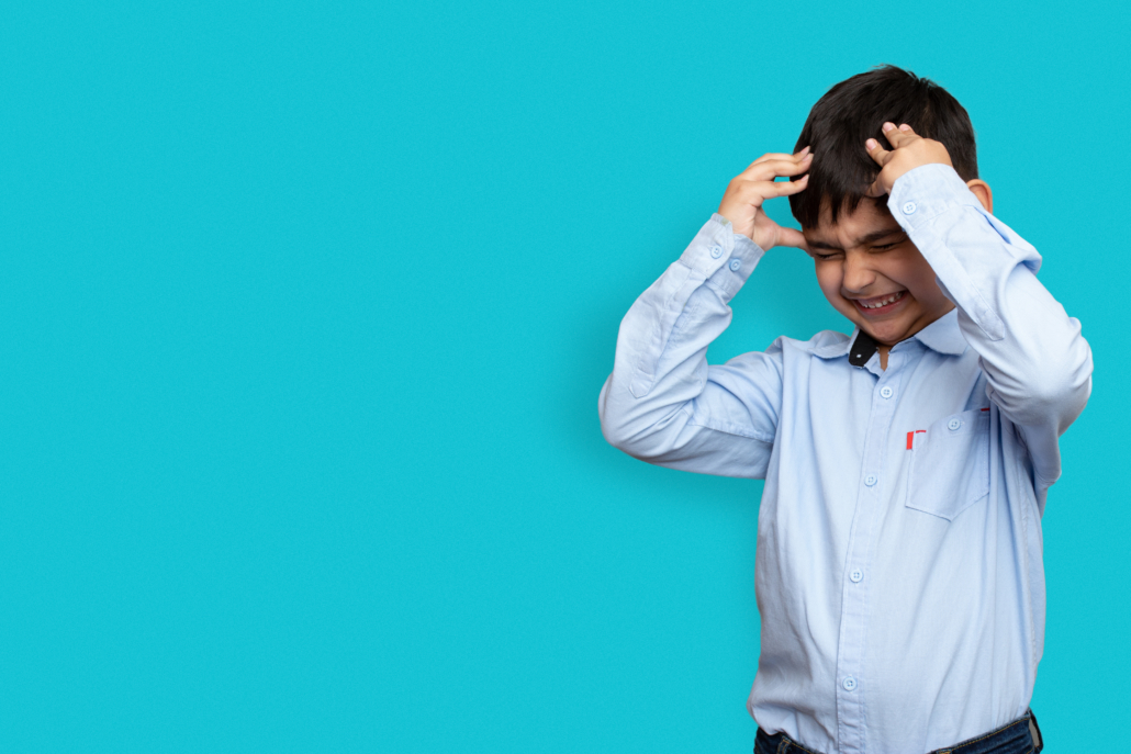 Sad and aggressive Little sick boy holding his head with his hand on plane isolated background with copy space