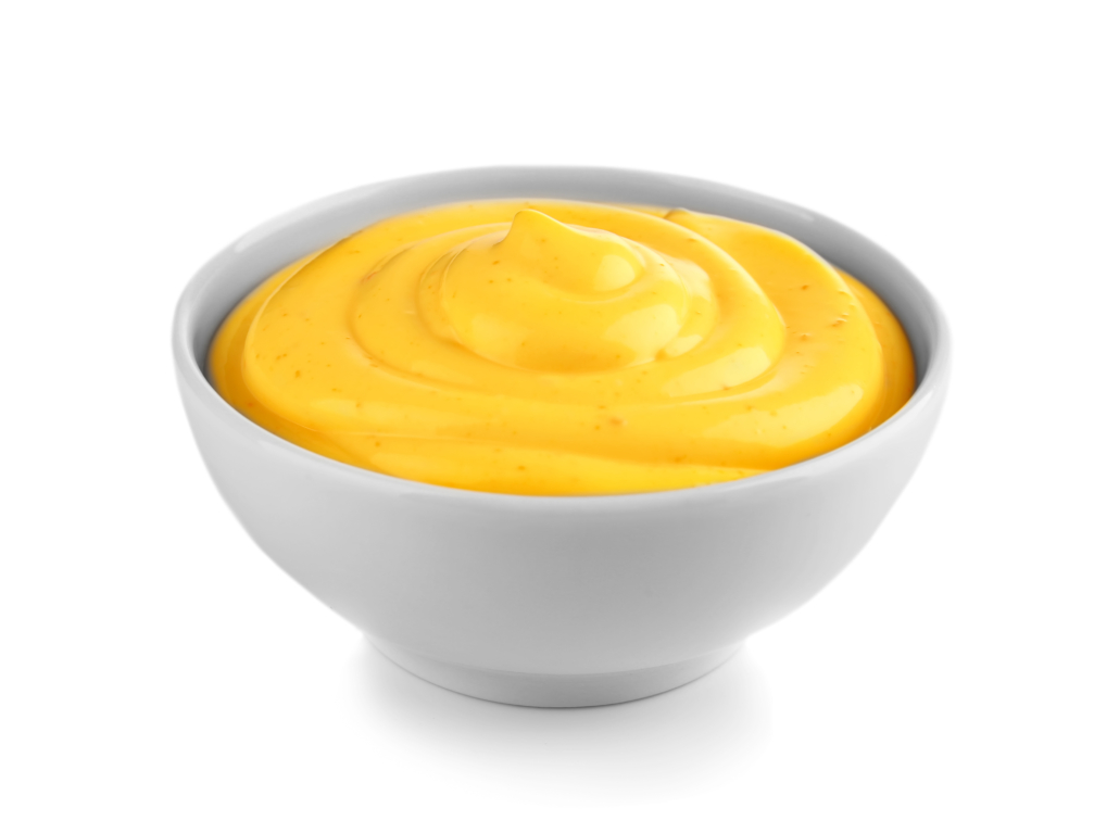 Bowl with cheese sauce on white background