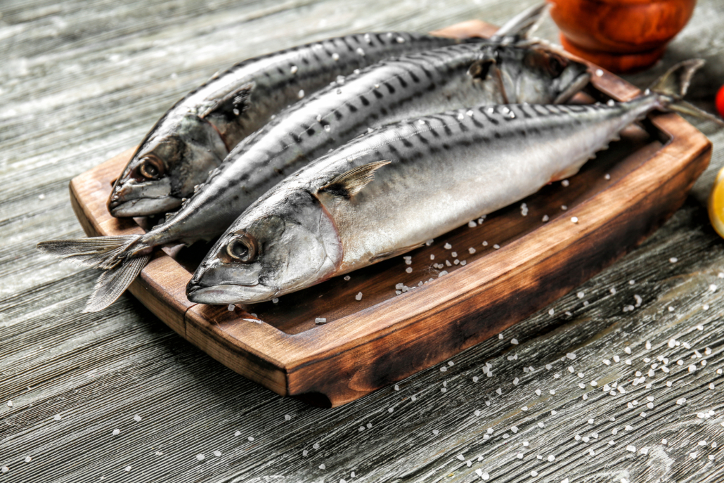 Board with tasty raw mackerel fish on wooden table