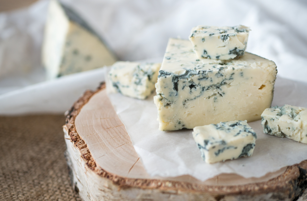 Tasty blue cheese on a wooden background and burlap. Dorblu chee