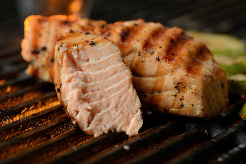 Grilled fish with vegetables and sauce, on the grill