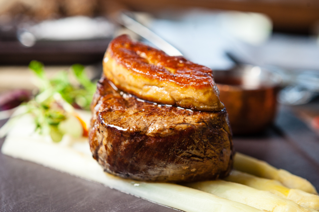 Tournedos Rossini. Foie gras, Black Angus beef tenderloin, white asparagus, red wine sauce. Delicious healthy traditional food closeup served for lunch in modern gourmet cuisine restaurant.