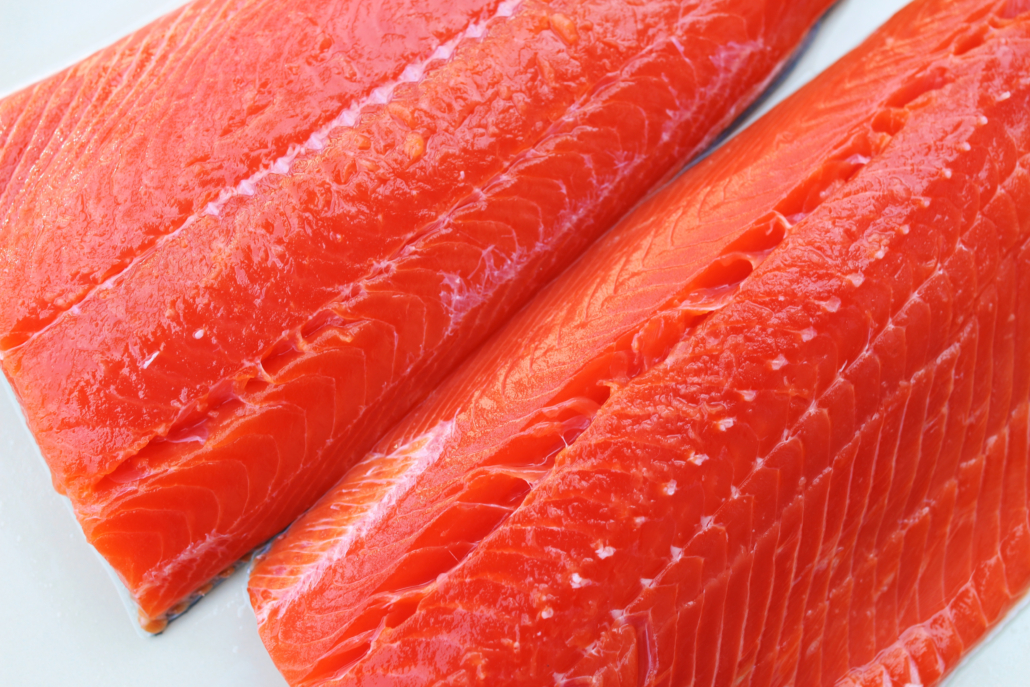 Wild-caught sockeye salmon fillets on a white background.