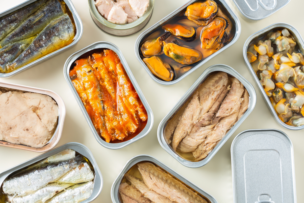 Assortment of different canned preserved fish and seafood in tin cans ready for tinned fish date night. Cheap and lowbrow food during economic crisis and inflation