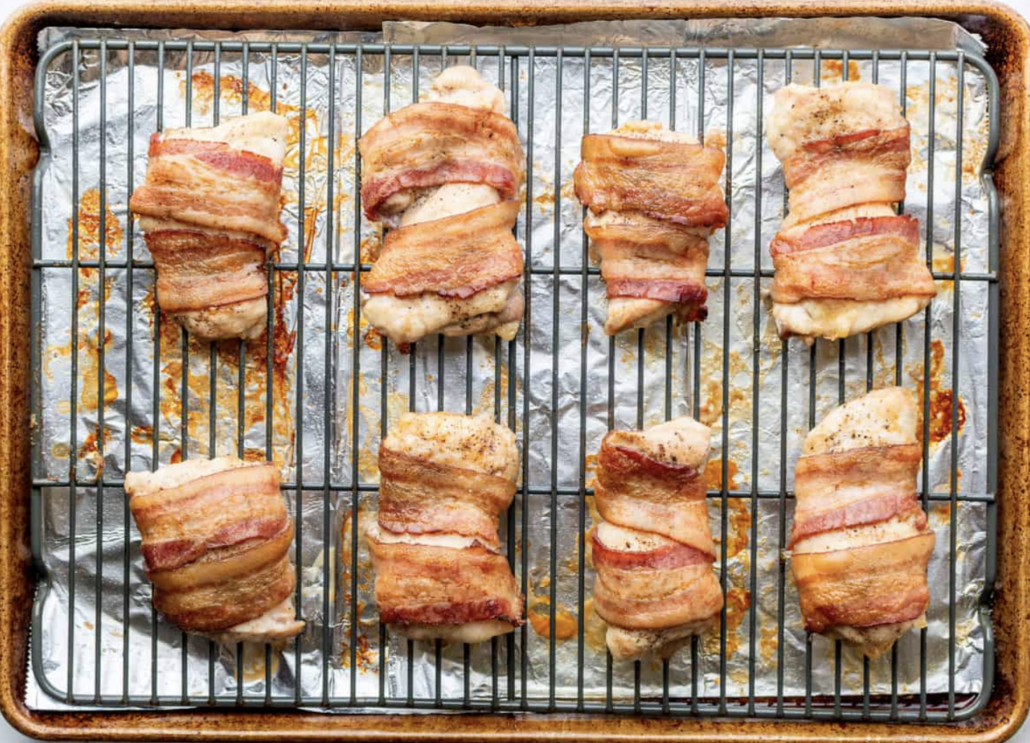 bacon wrapped chicken thighs on a tray