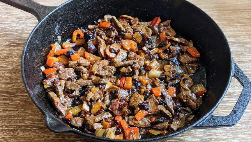 close up of beef liver with figs in skillet