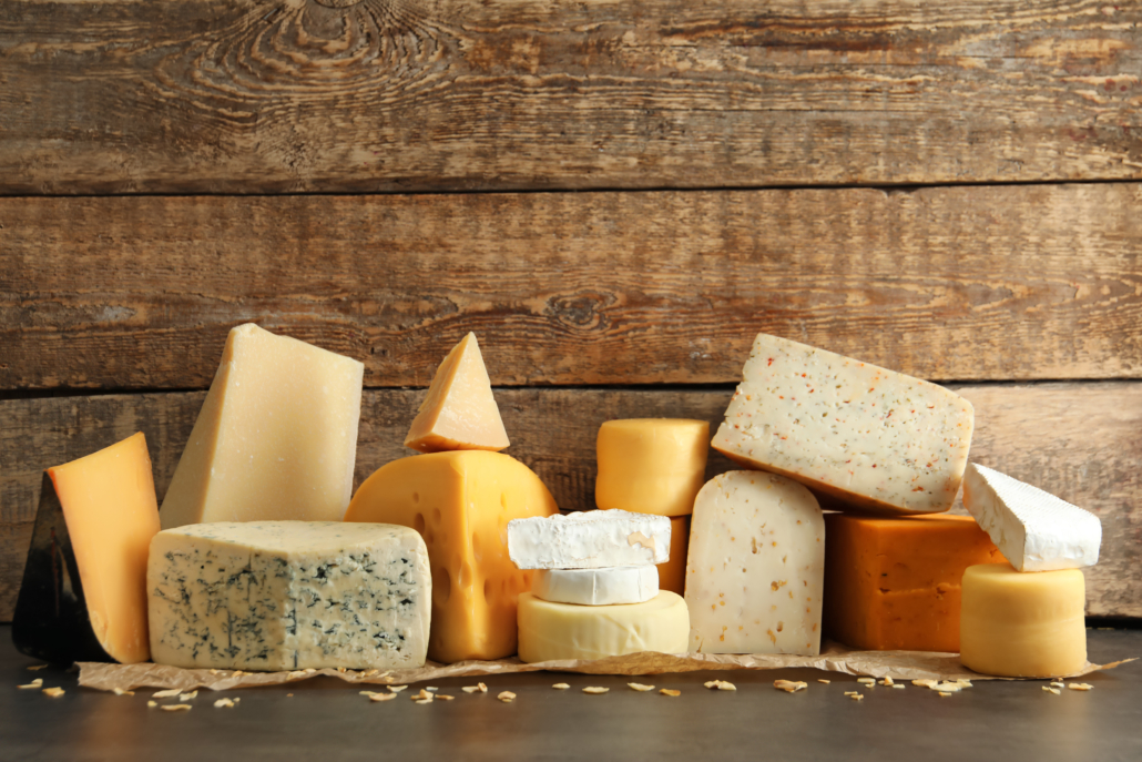 Different kinds of delicious cheese on table