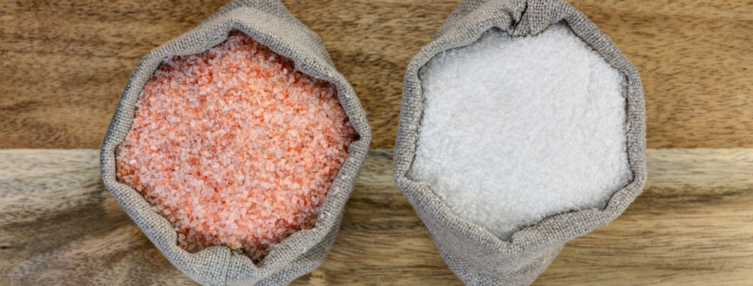 Sea salt and pink salt in the linen sacks on the wooden background