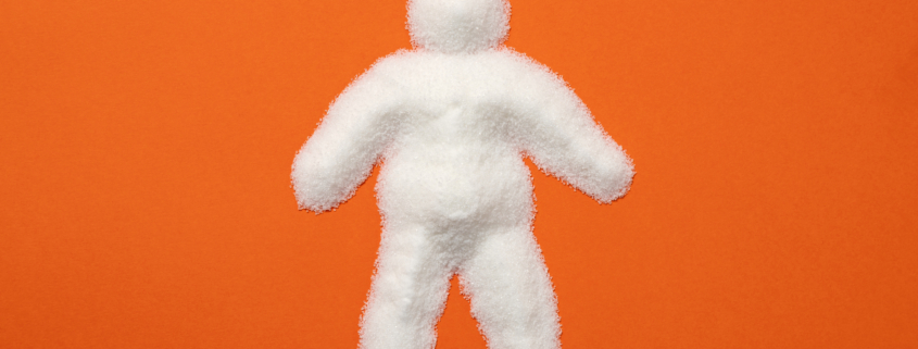 Obese man silhouette made with lots of refined white powdered sugar. Visual metaphor indicating the harmful effects of sugar on the human body.